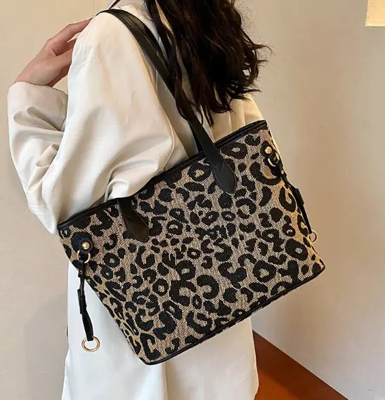 Woman carrying a black-handled leopard print Shoulder Tote Bag, showcasing its spacious interior and trendy design.