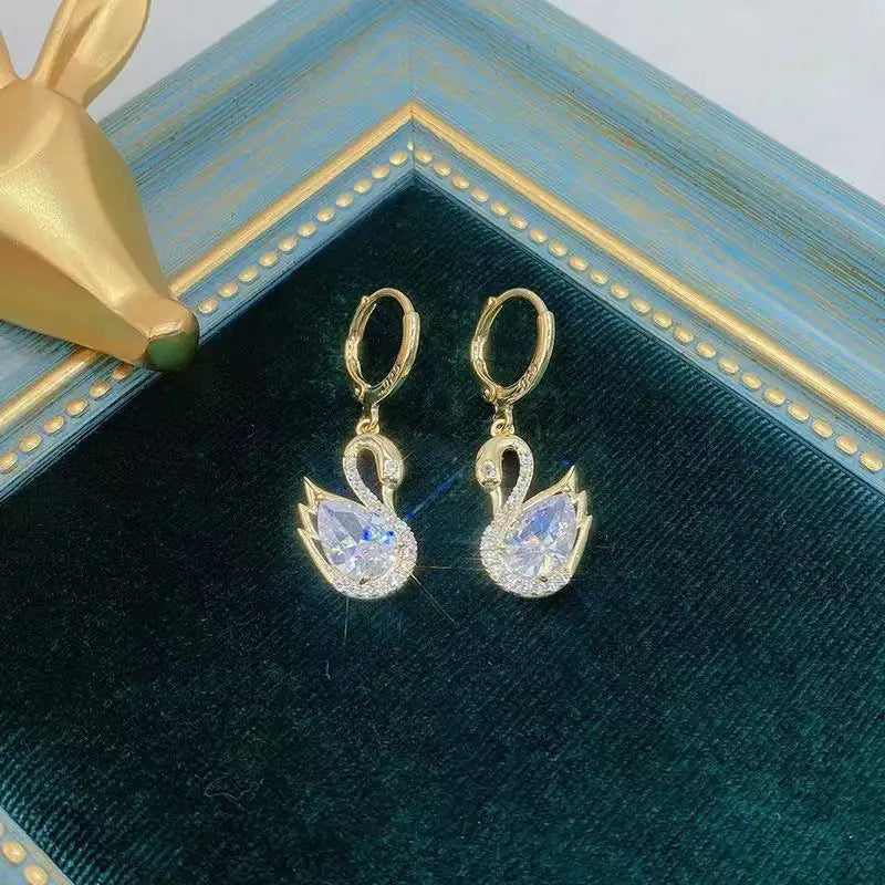Pair of European Style Luxury Temperament Copper Zirconium Swan Pendant Earrings displayed on a velvet jewelry tray, showcasing their floral elegance.