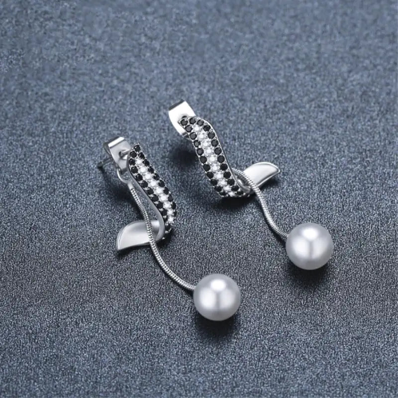 High-grade light luxury tassel earrings featuring pearl drops and black crystal embellishments, ideal for women's fashion accessories.