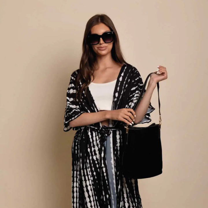 Model holding the Blake Shoulder Bag -Black, emphasizing its sleek bucket shape and soft suede-like vegan leather finish.