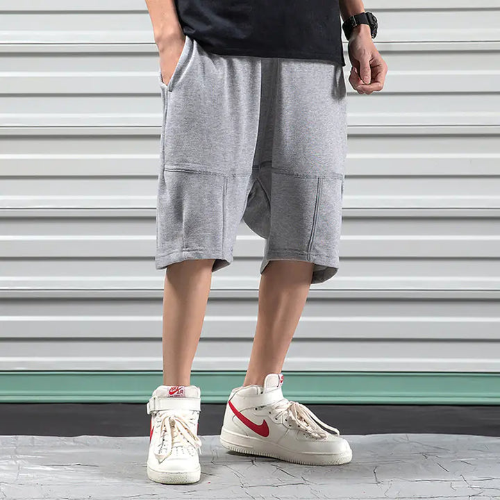 Gray Hip-Hop Sports Shorts for Men with relaxed fit and cotton fabric, styled with red-accented sneakers.