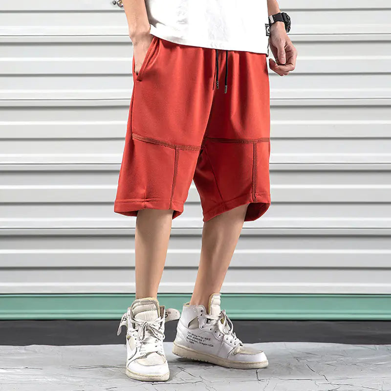 Red Hip-Hop Sports Shorts for Men featuring relaxed harem silhouette and drawstring waist, paired with white high-top sneakers.
